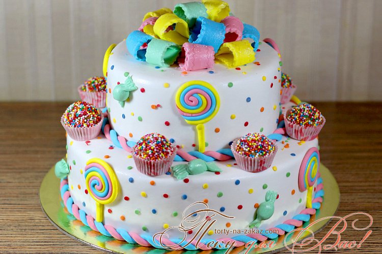 Праздничный двухъярусный мастичный торт украшенный пирожными
